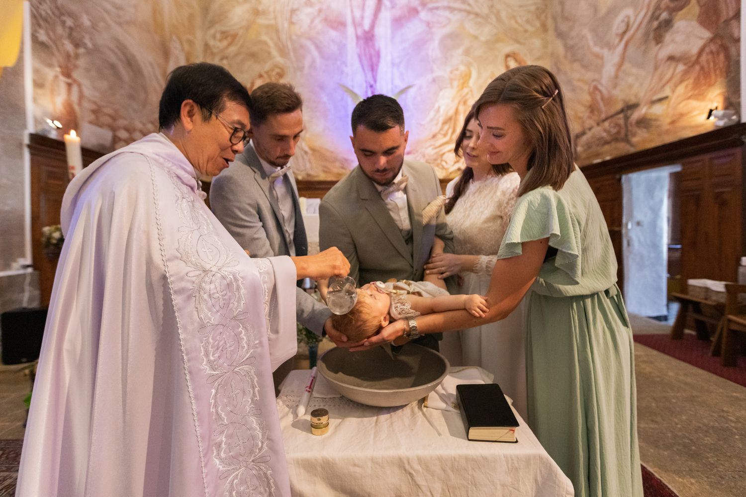 Enfant qui se fait baptiser dans une église, à Cotignac