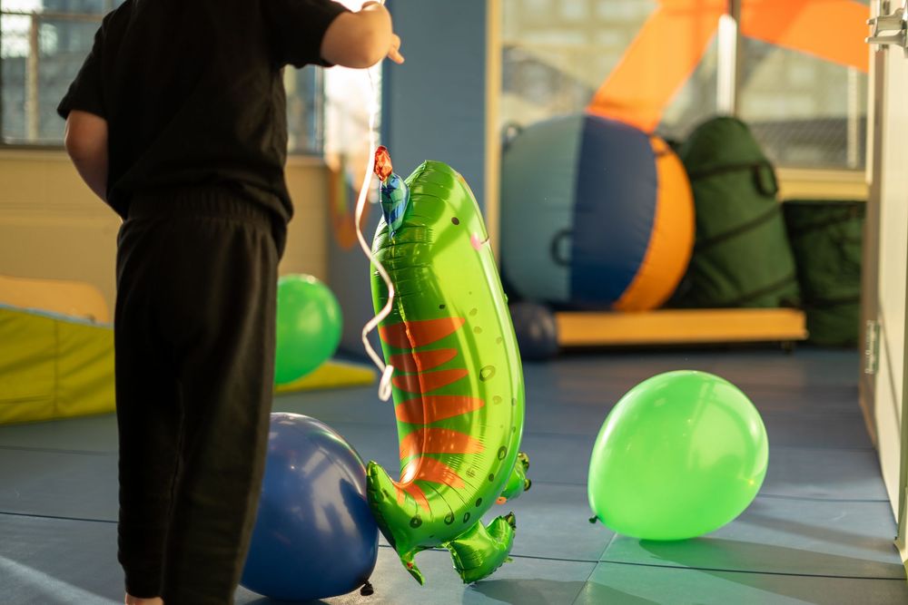 Two people in orange and neon yellow safety vests work together in a warehouse setting.