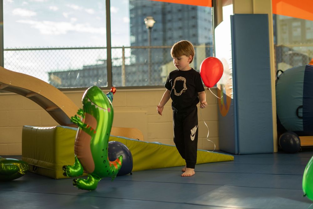 A sequence of parkour athletes performing flips and acrobatic movements in an indoor training facility.