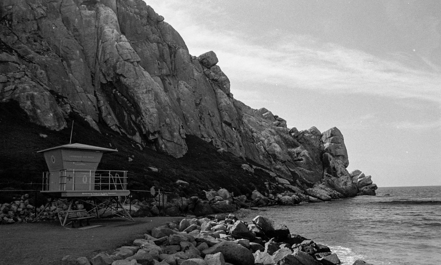 A series of black and white coastal landscape photographs showing rocky cliffs and ocean views along a shoreline.