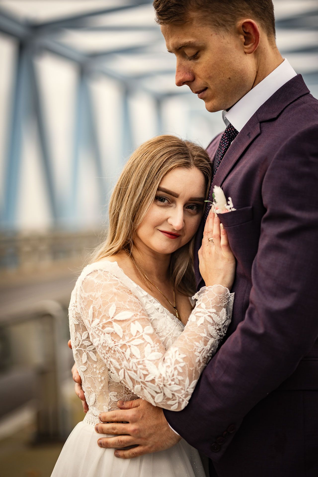 An intimate moment between newlyweds on a steel bridge.