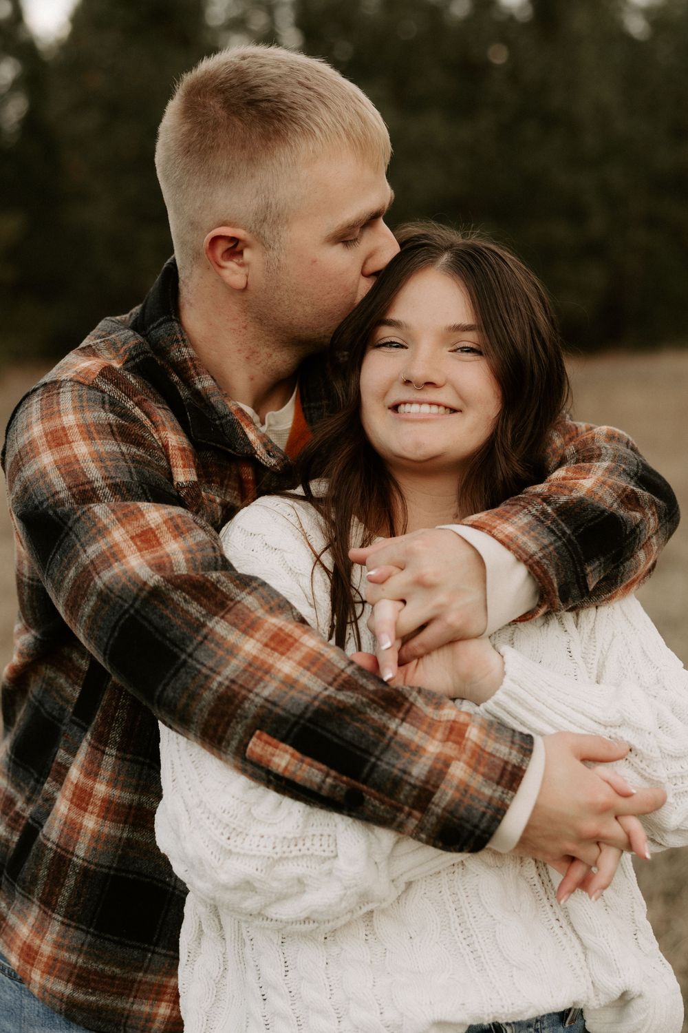 Romantic couple in plaid shirt and white sweater sharing intimate embraces in a series of candid outdoor photos.