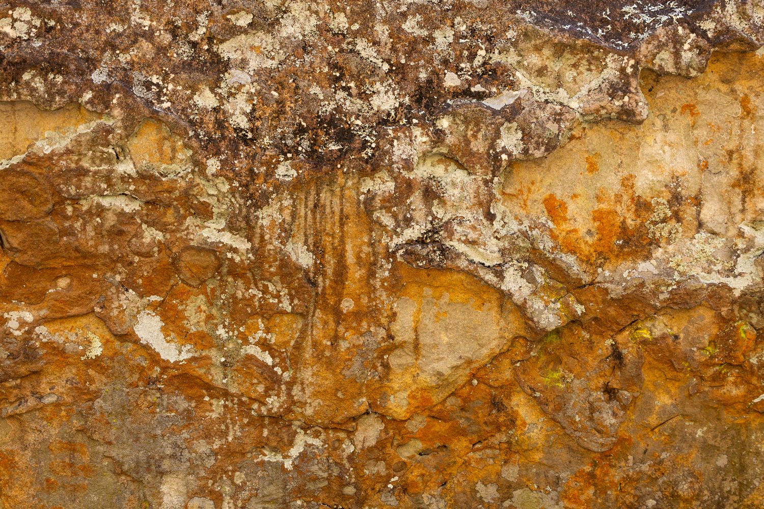 Rustic textured wall surface showing layers of orange and brown paint with white peeling patterns and weathered effects.