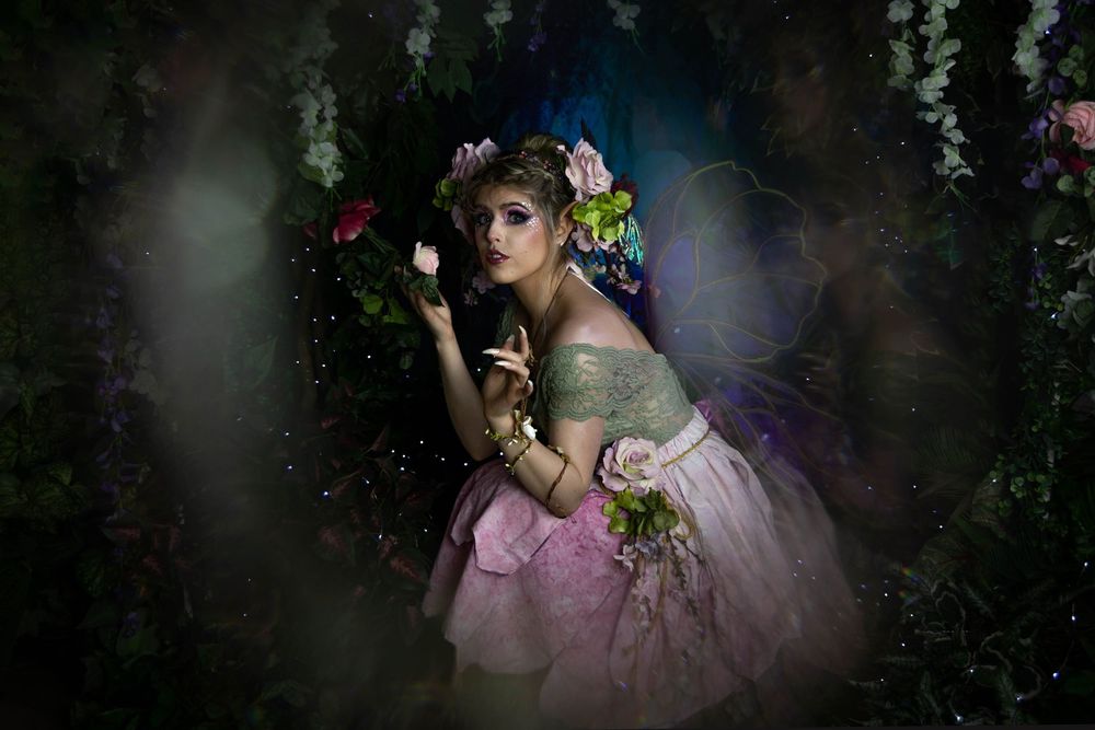 A fairy examining some flowers.