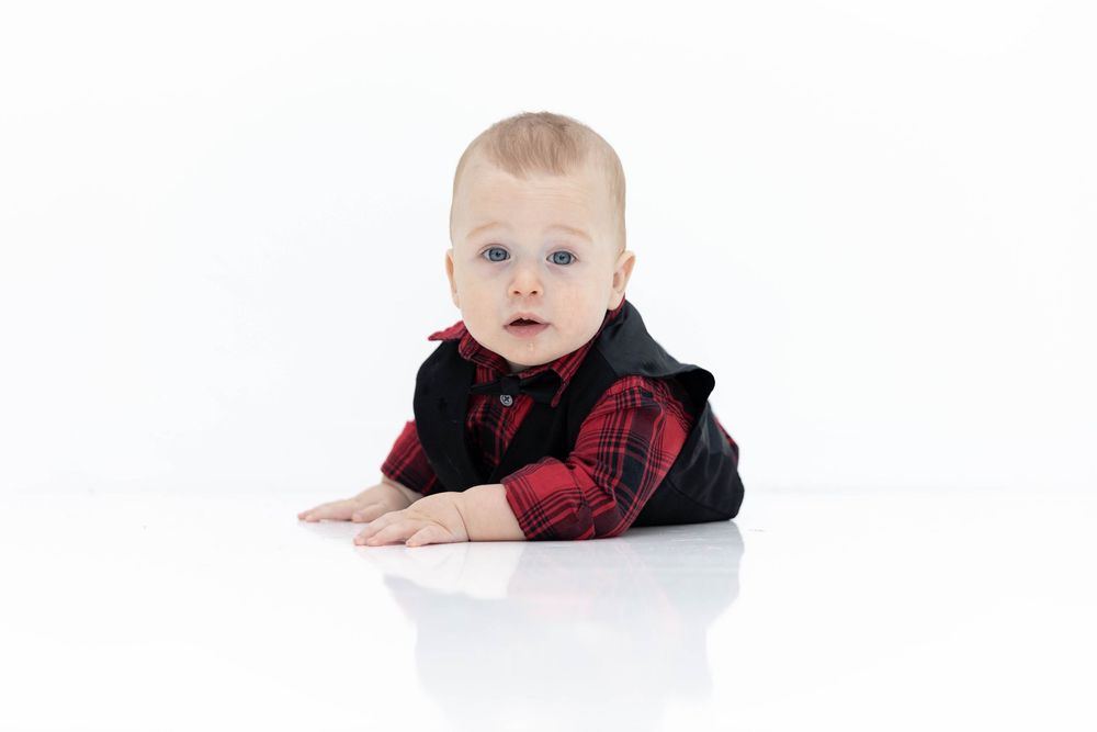 A baby in an all white room.