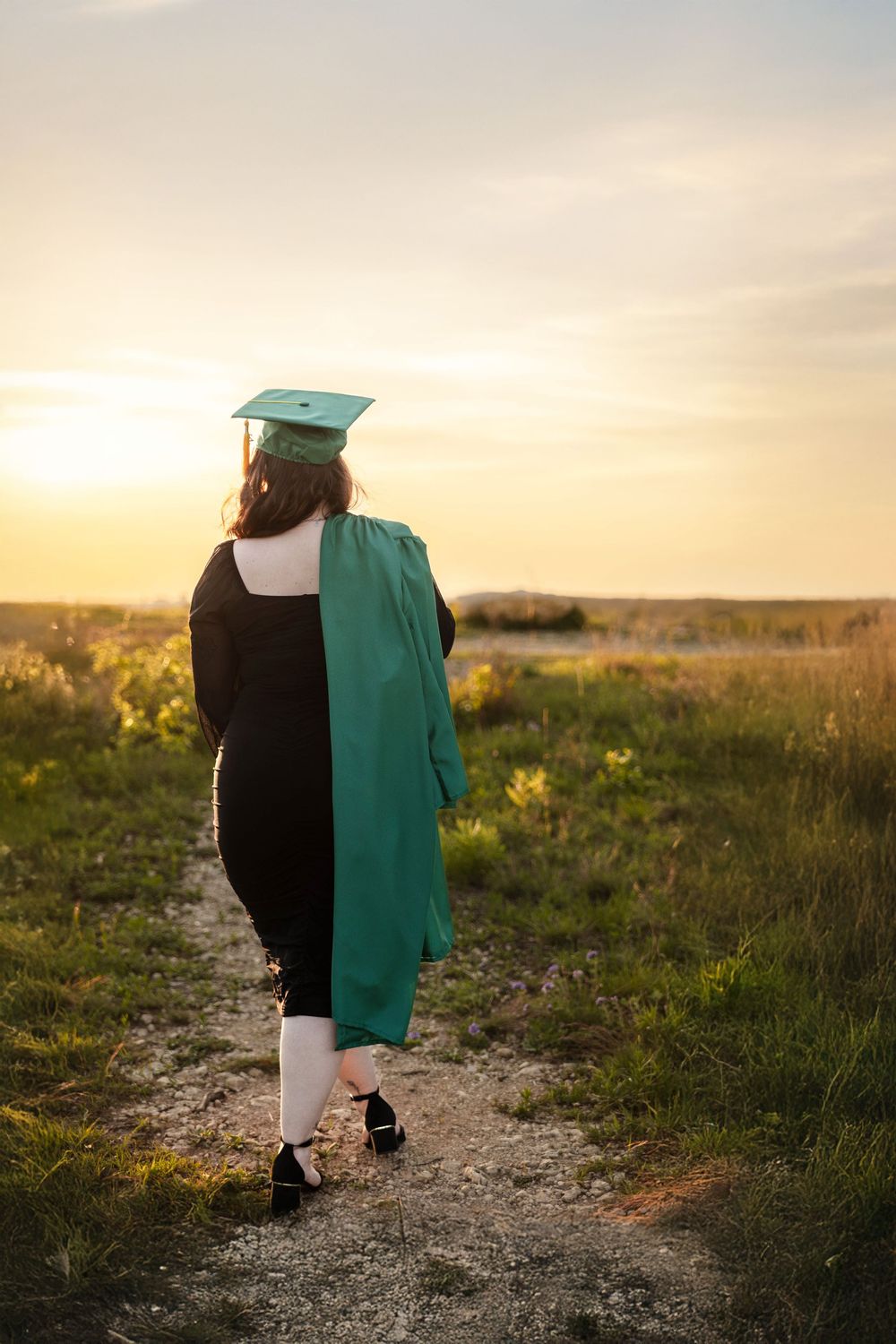 A graduating senior stares off into the sunset for a photo.