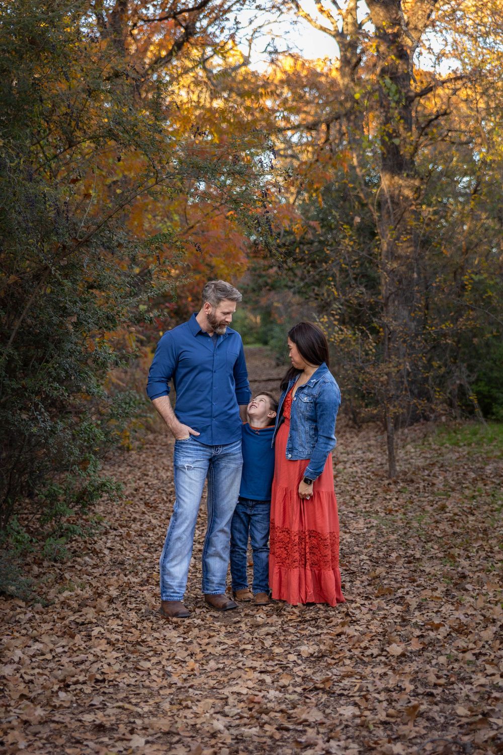 A family poses for a family photo in the park.