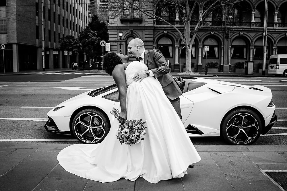 A series of black and white wedding photos showing a couple in formal attire outside a historic building.