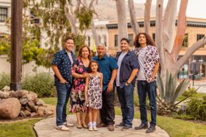 A group portrait of people in coordinated outfits standing together in a garden setting.
