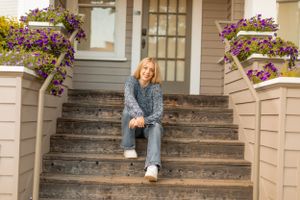 Casual denim outfit on concrete steps with purple flowers in planters.