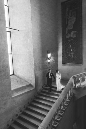 Four black and white photographs showing a dark stone staircase with dramatic shadows and windows in a medieval castle interior.