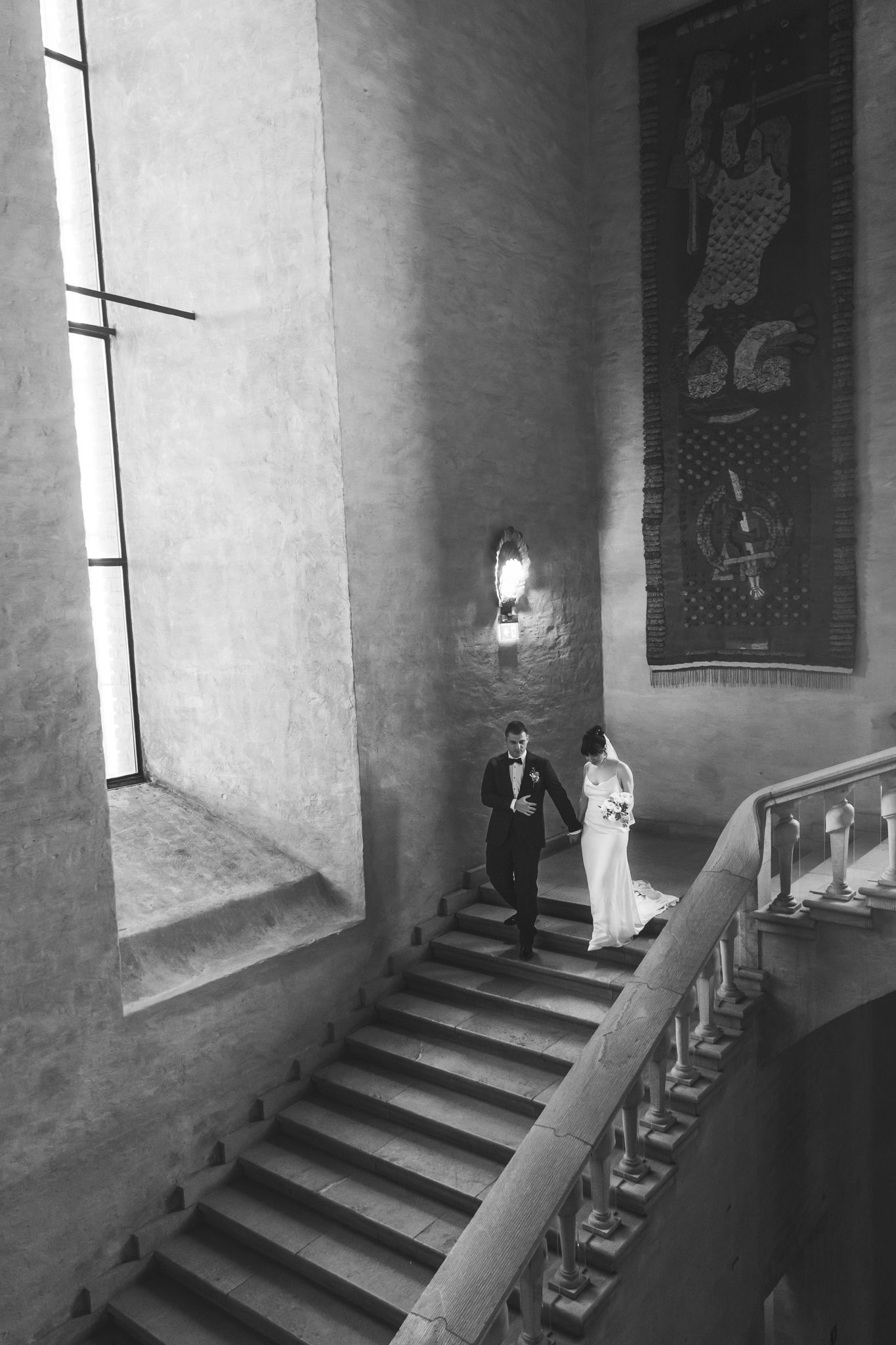 Four black and white photographs showing a dark stone staircase with dramatic shadows and windows in a medieval castle interior.