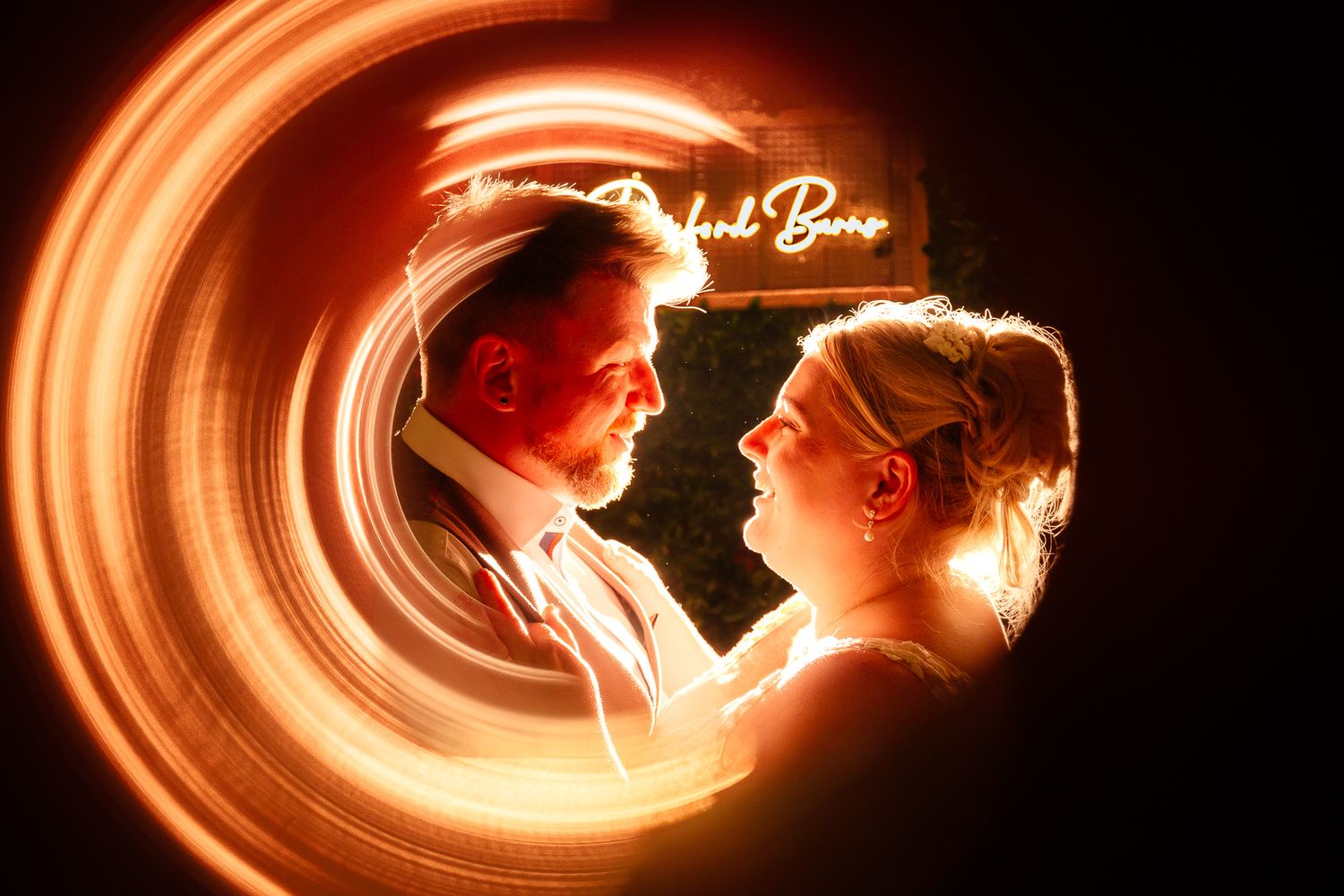 Creative light painting photography with glowing orange spiral effects in darkness.
