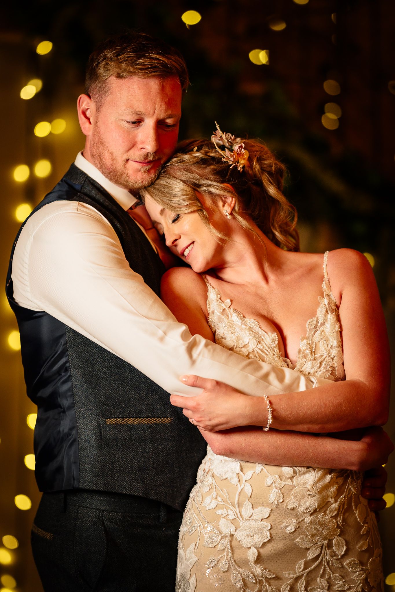 Intimate dance moment captured with warm bokeh lights in background.