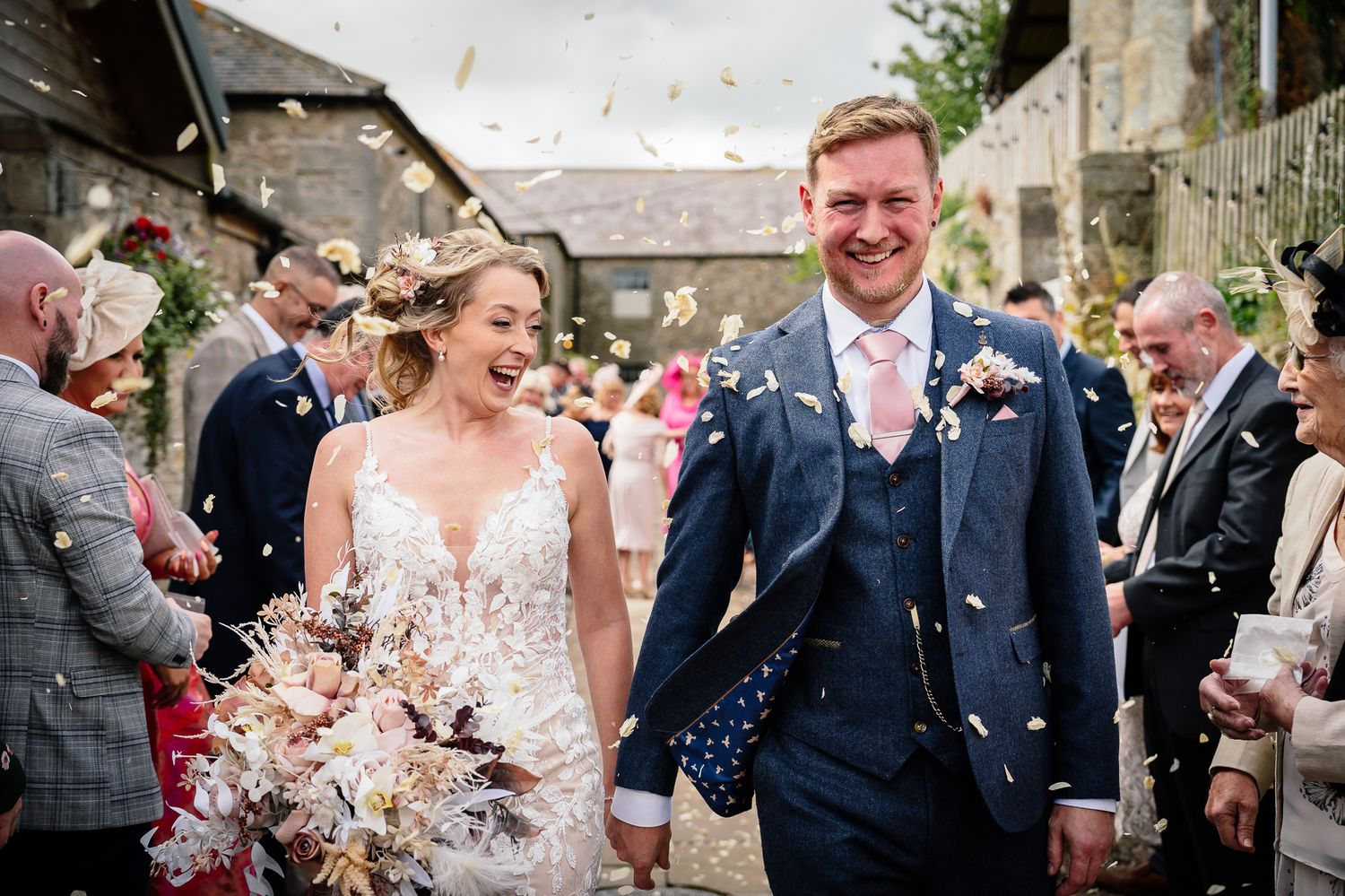 Wedding guests showering newlyweds with confetti during outdoor celebration.