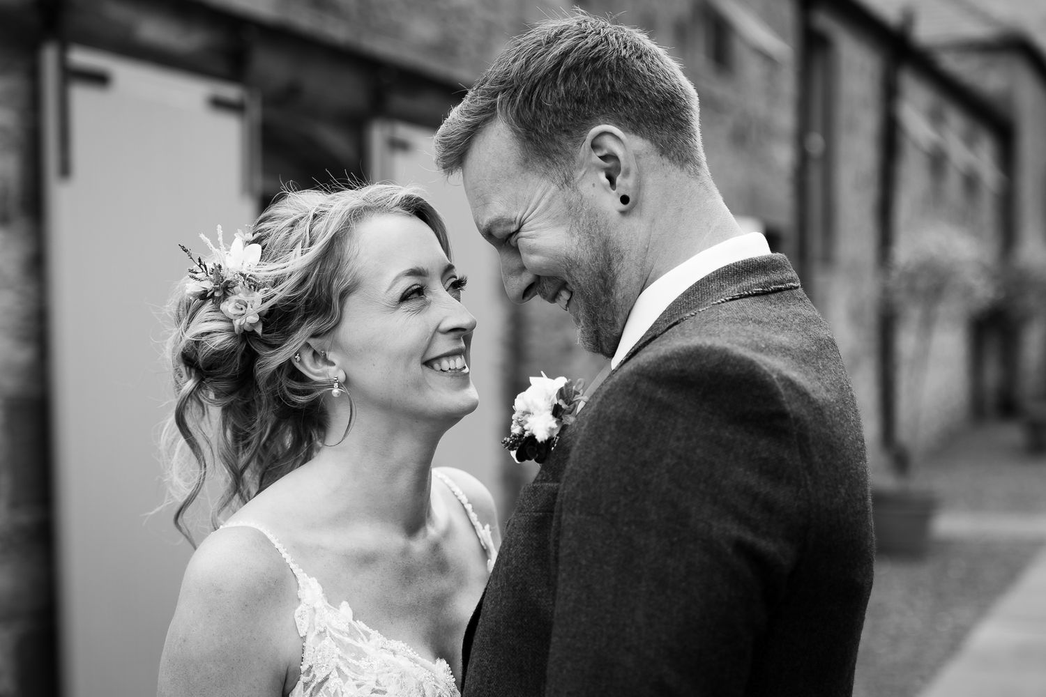Black and white intimate portrait of a wedding couple sharing a tender moment.