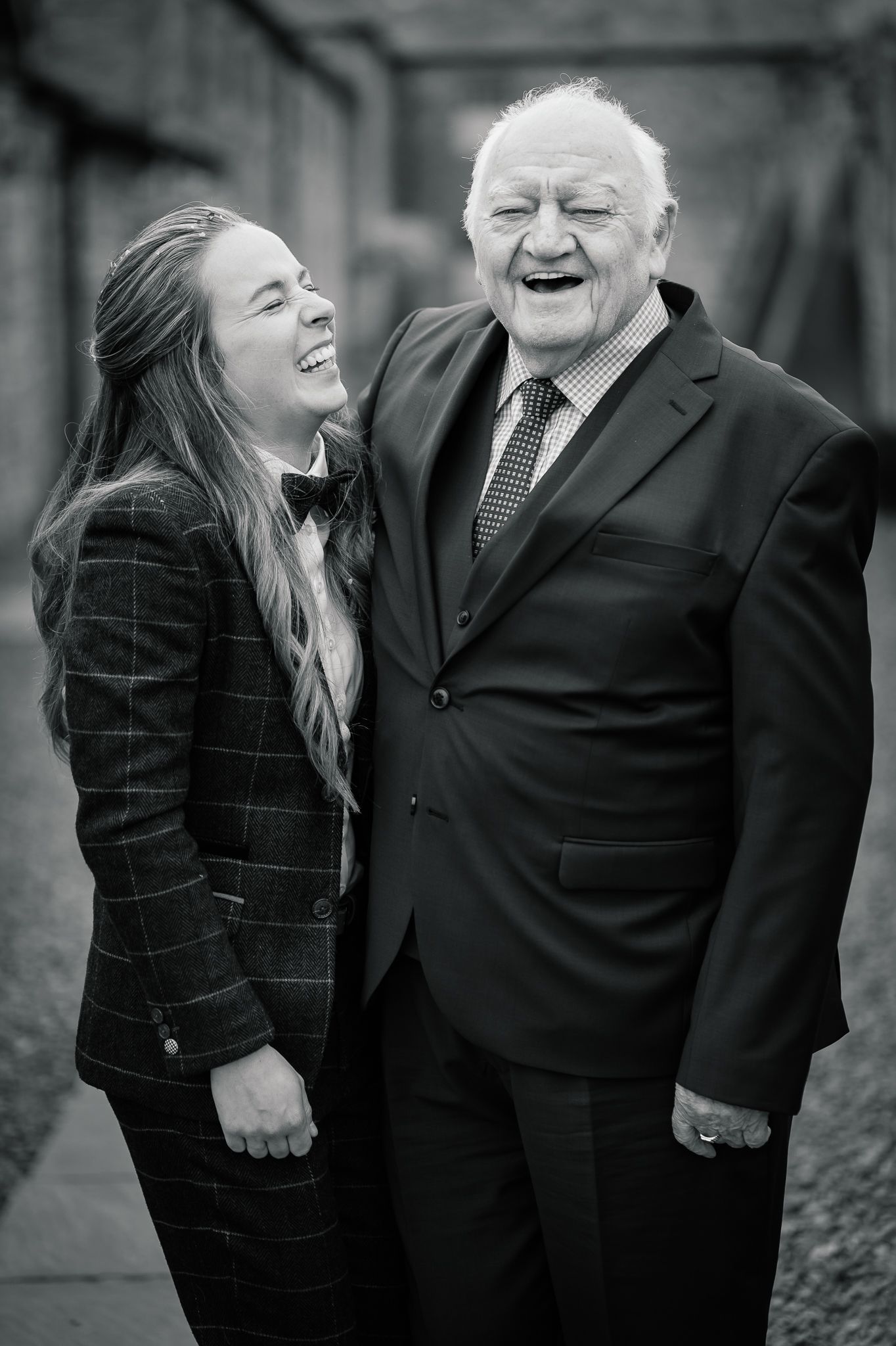 Black and white candid photos showing joyful laughter and warm embraces between two people.