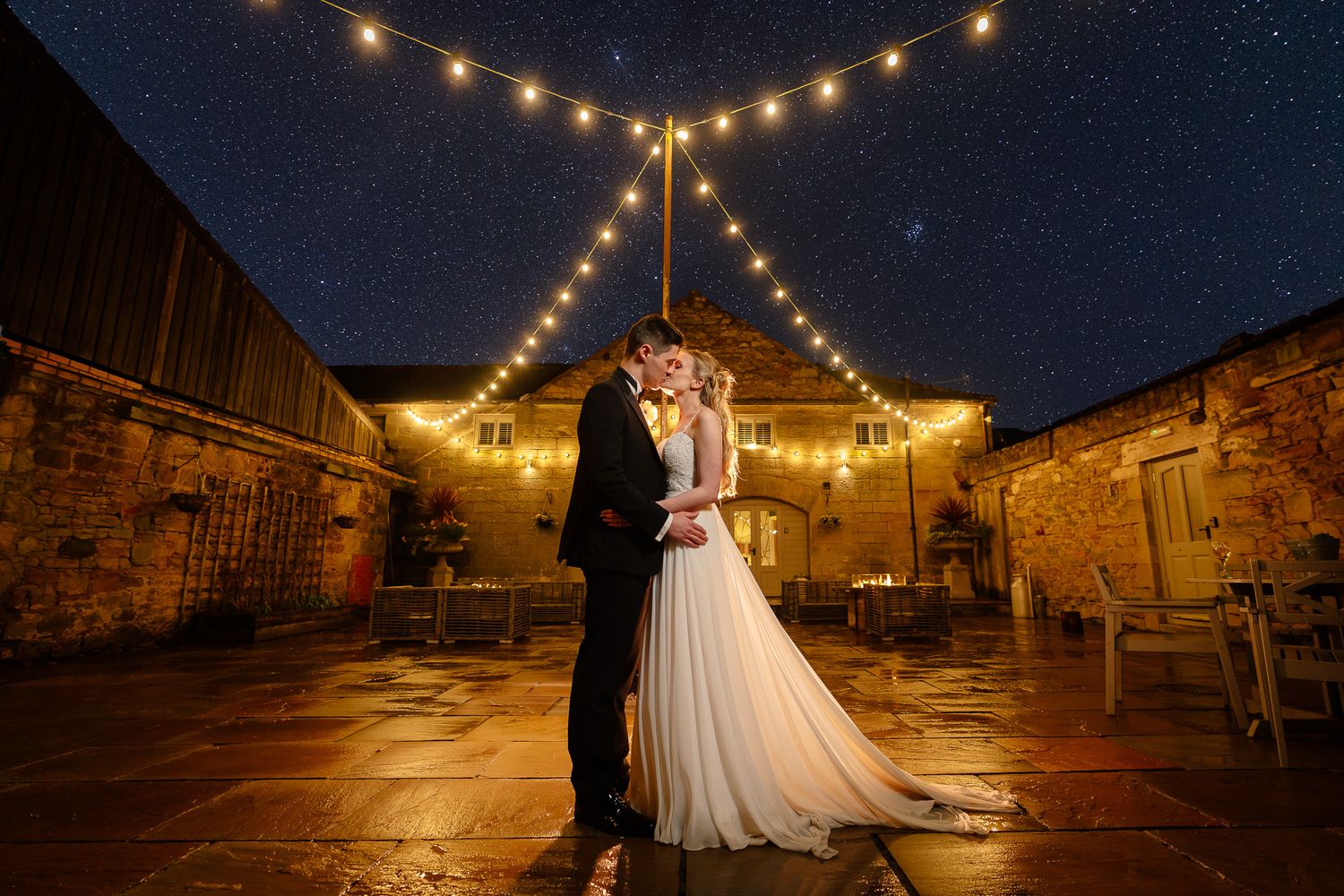 Wedding venue exterior with string lights creating romantic ambiance at night. Doxford Barns