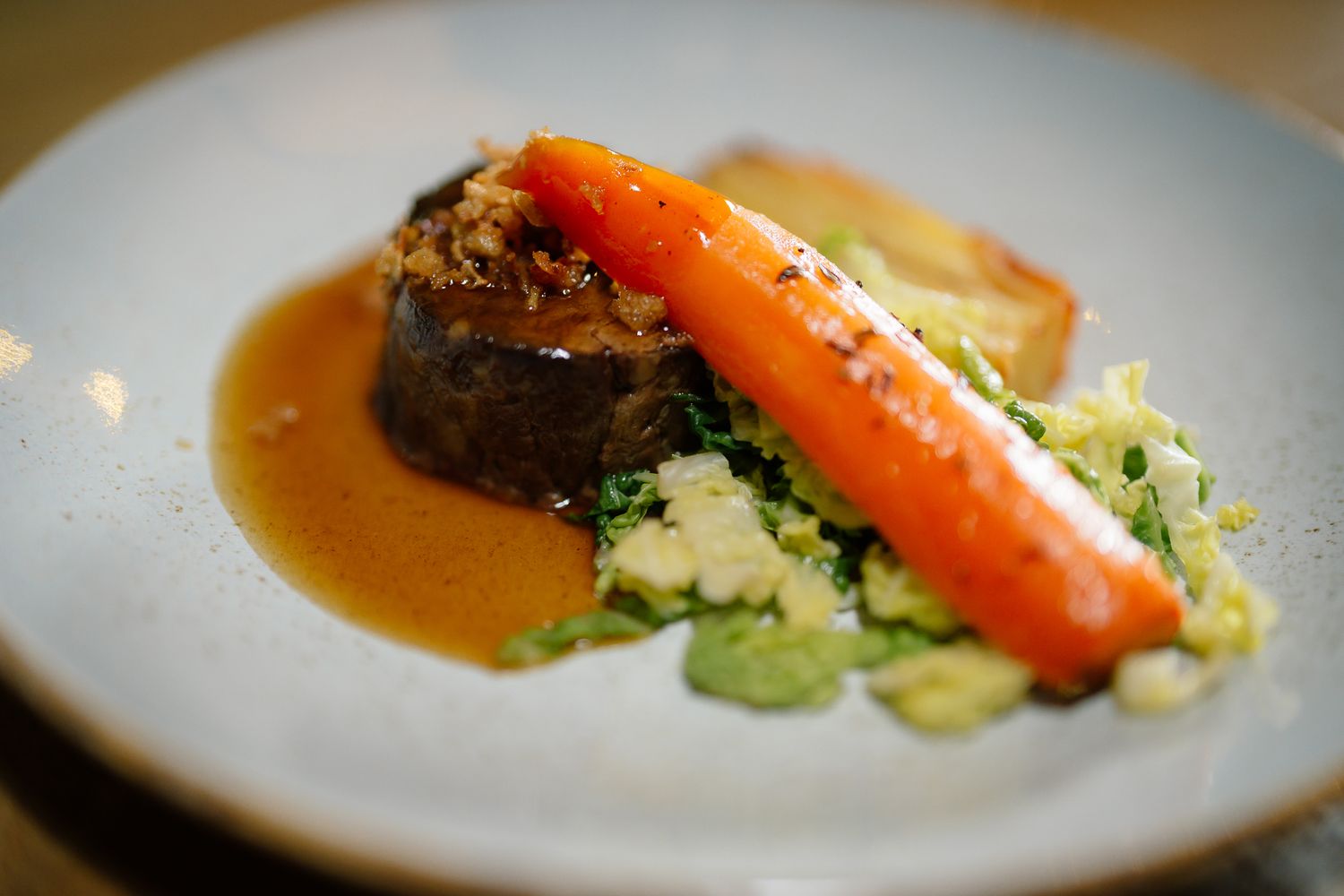 Elegant plated dinner course with carrots and sauce on white dish. Doxford Barns
