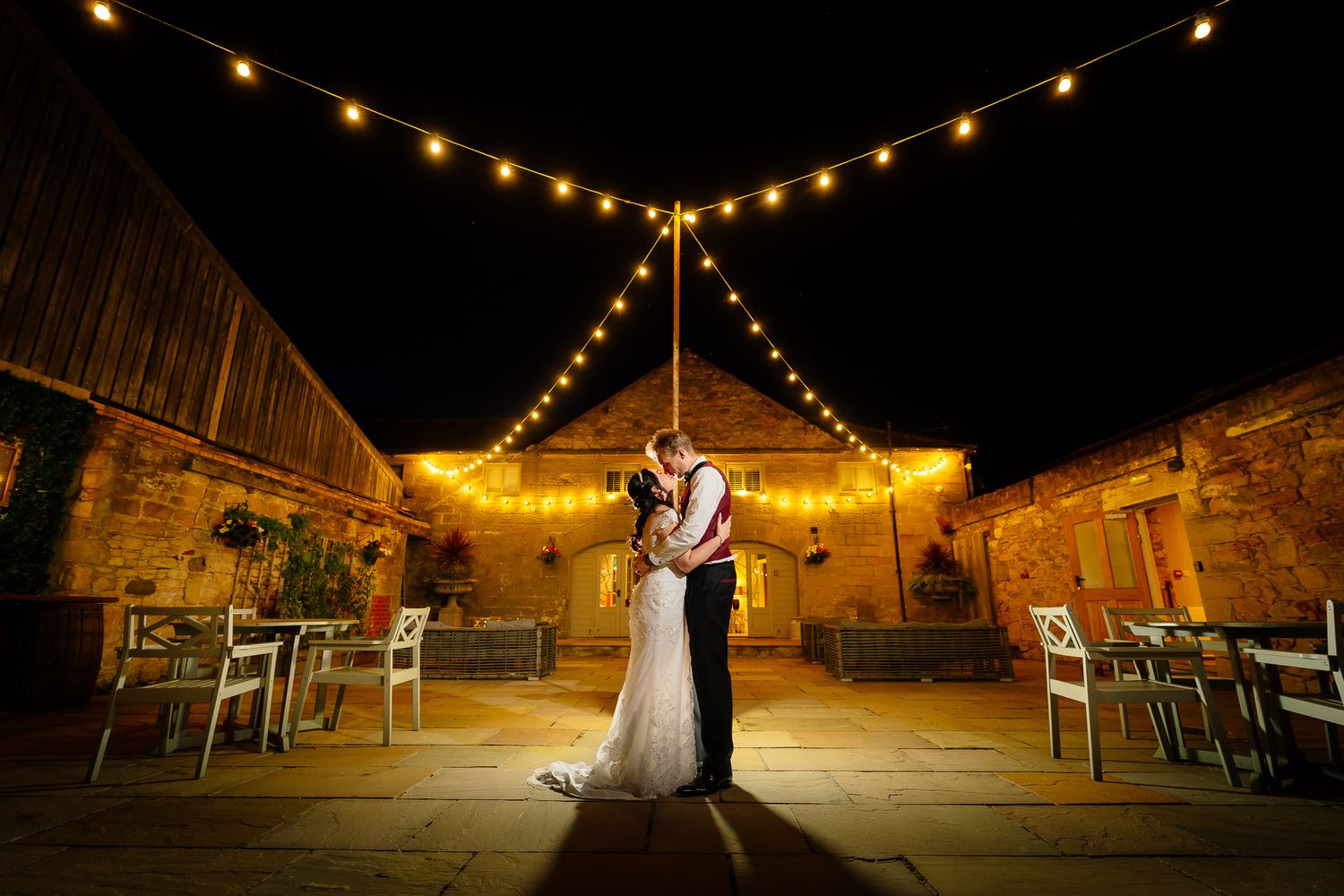 Rustic barn venue decorated with string lights creating a magical evening atmosphere.Doxford Barns