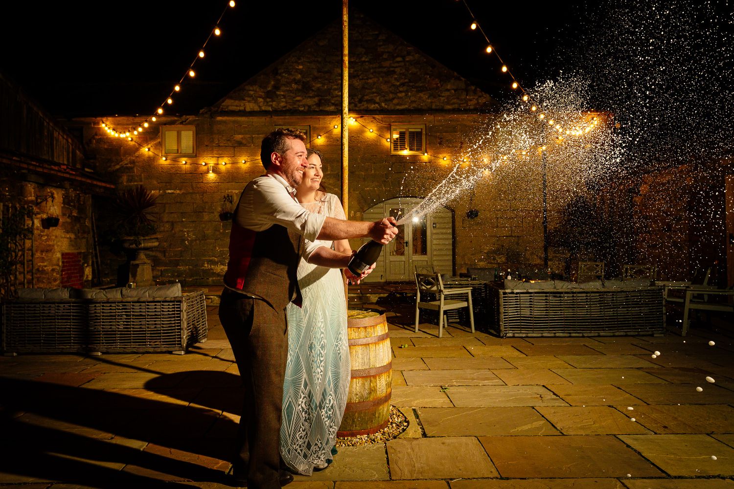 Romantic nighttime wedding photos with string lights creating magical atmosphere. Doxford Barns