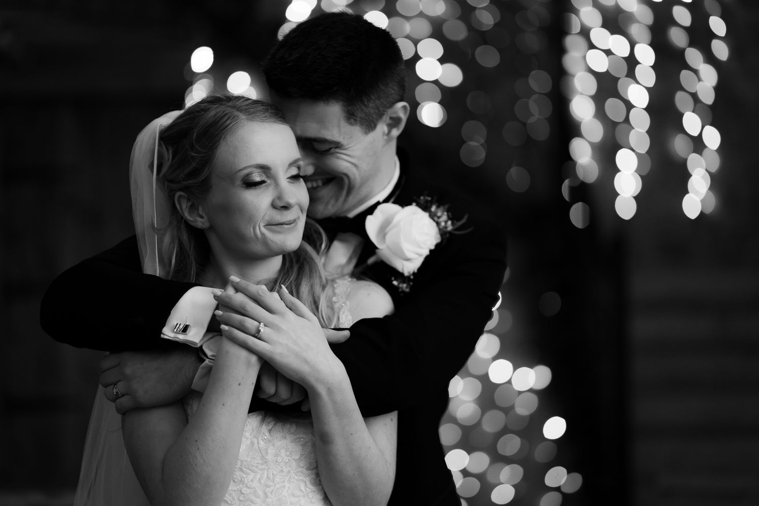 Intimate black and white dance moment at wedding reception with bokeh lights. Doxford Barns