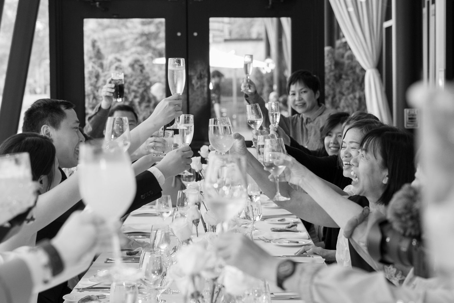 Black and white photo sequence showing wedding reception guests laughing and celebrating at tables during a dinner party.