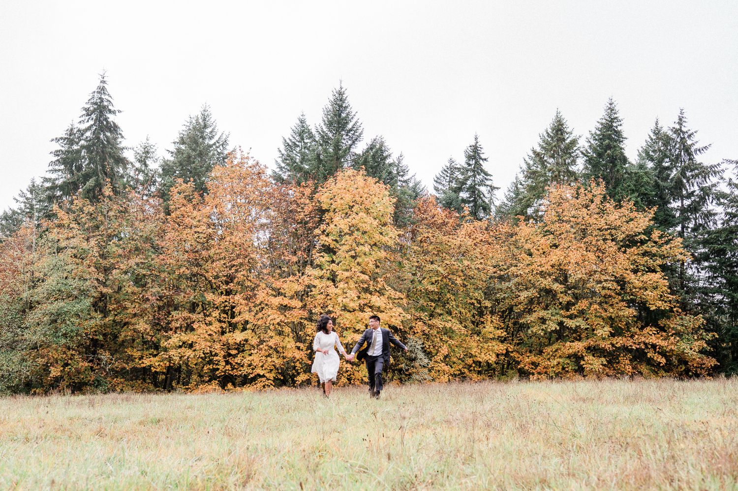 bride and groom running in field on an autumn day. photo by Bainbridge island Elopement Photographer