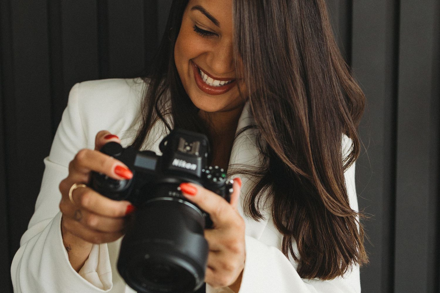 Photography sequence showing interaction with camera equipment against dark backdrop.