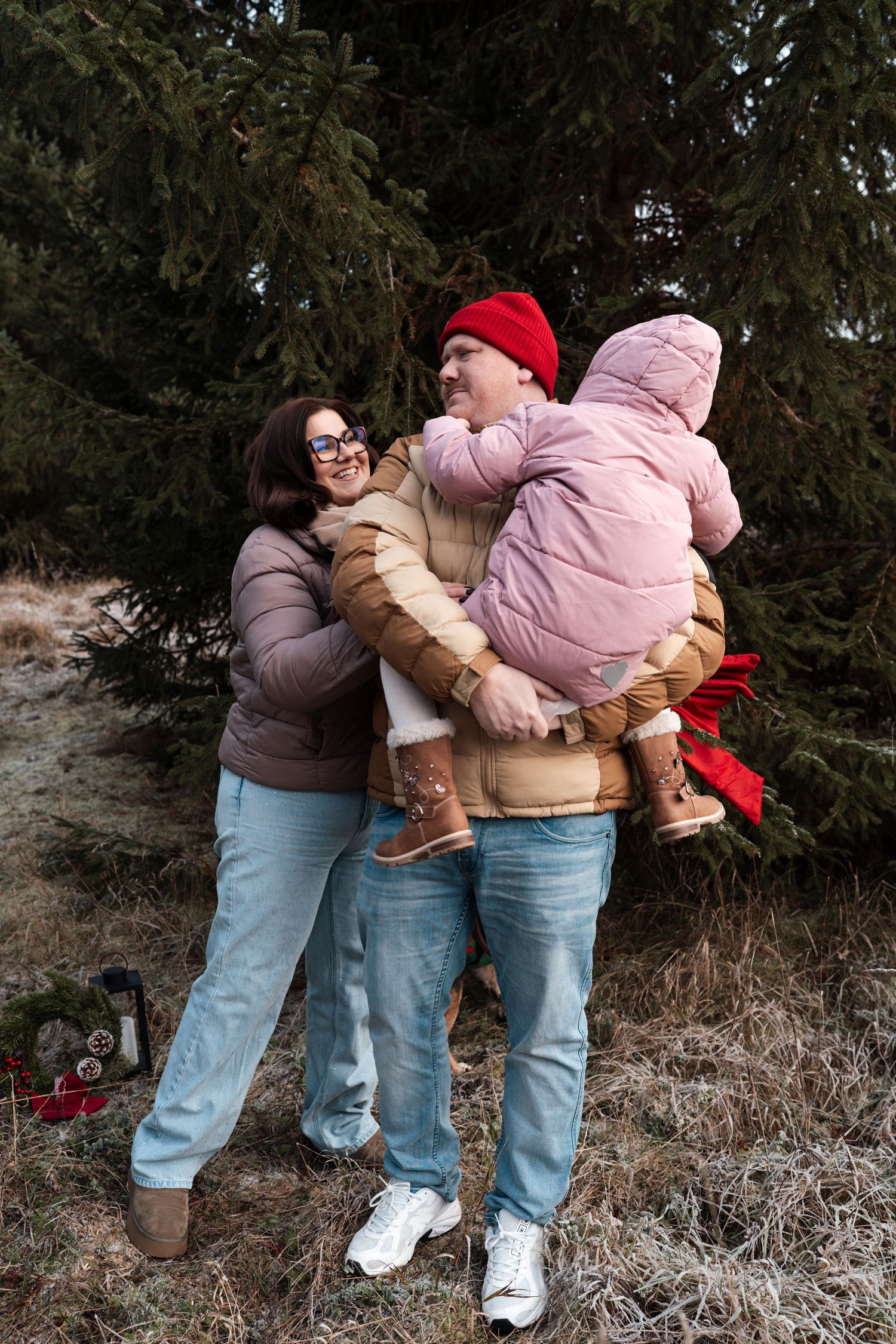 Eine Familie steht vor weihnachtlichen Tannenbaum. Familienfotografie - Coffee and Stories Fotografie