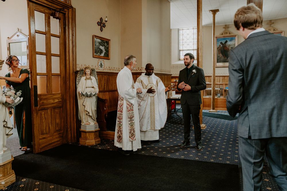 groom and priest talking before wedding ceremony begins