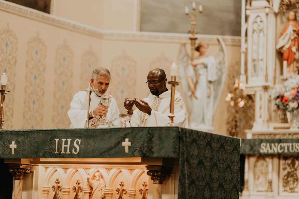 priests break bread at church service