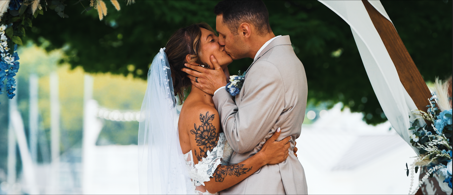 A couple embraces in romantic wedding photos outdoors with soft natural lighting and elegant formal attire.