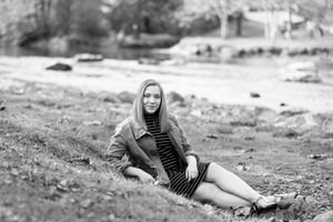 Black and white outdoor portrait series showing casual poses on natural terrain.