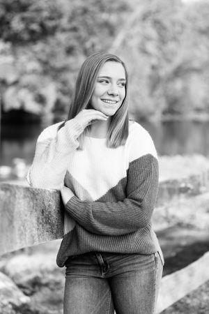 Black and white portrait series showing casual poses against a natural outdoor setting.