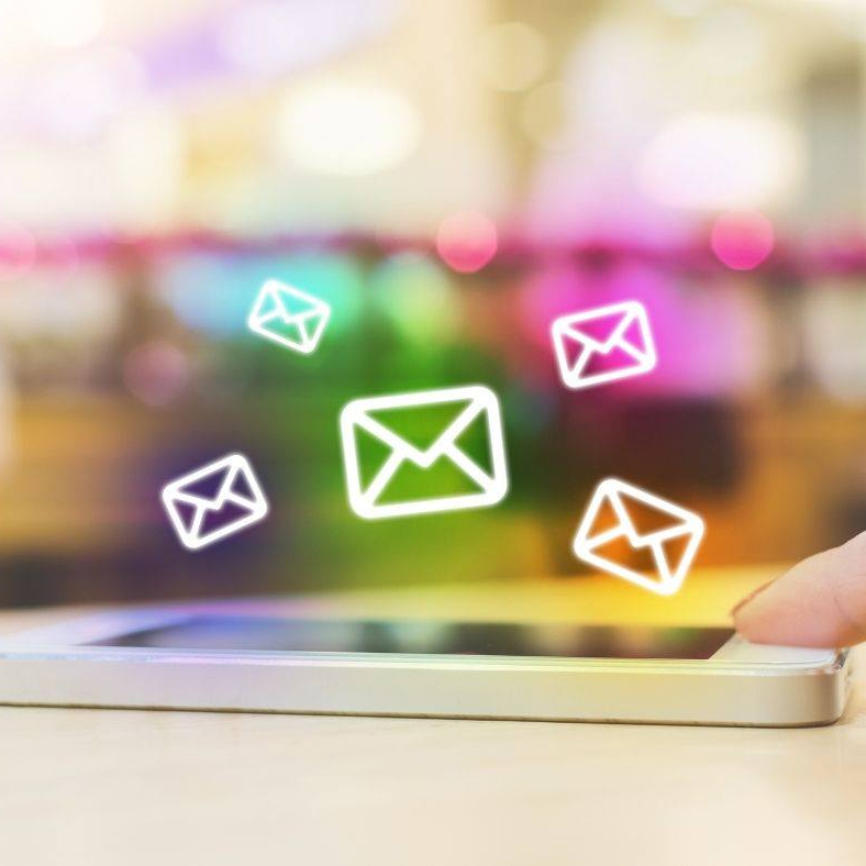 Blurred colorful bokeh background with glowing white envelope icons floating across the frame.