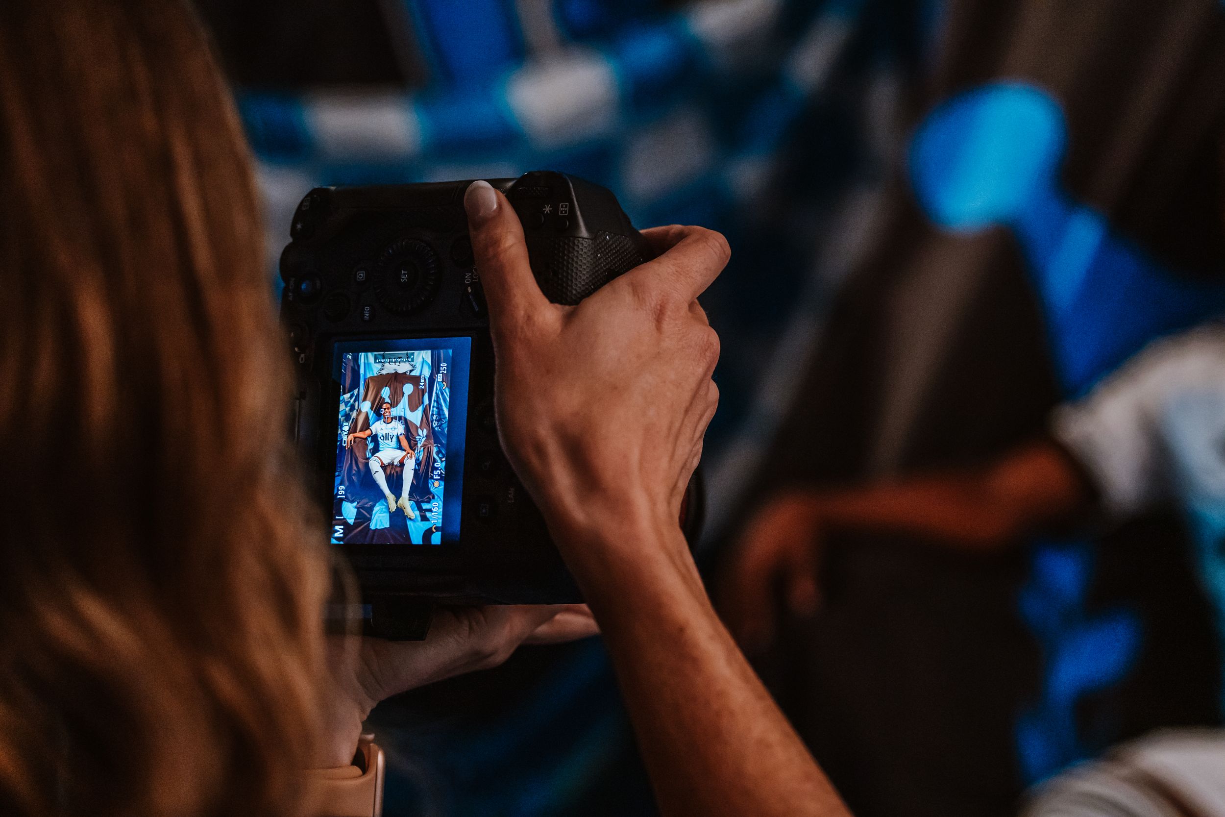 A photographer captures a Charlotte FC player portrait on a DSLR camera screen during a photo shoot.