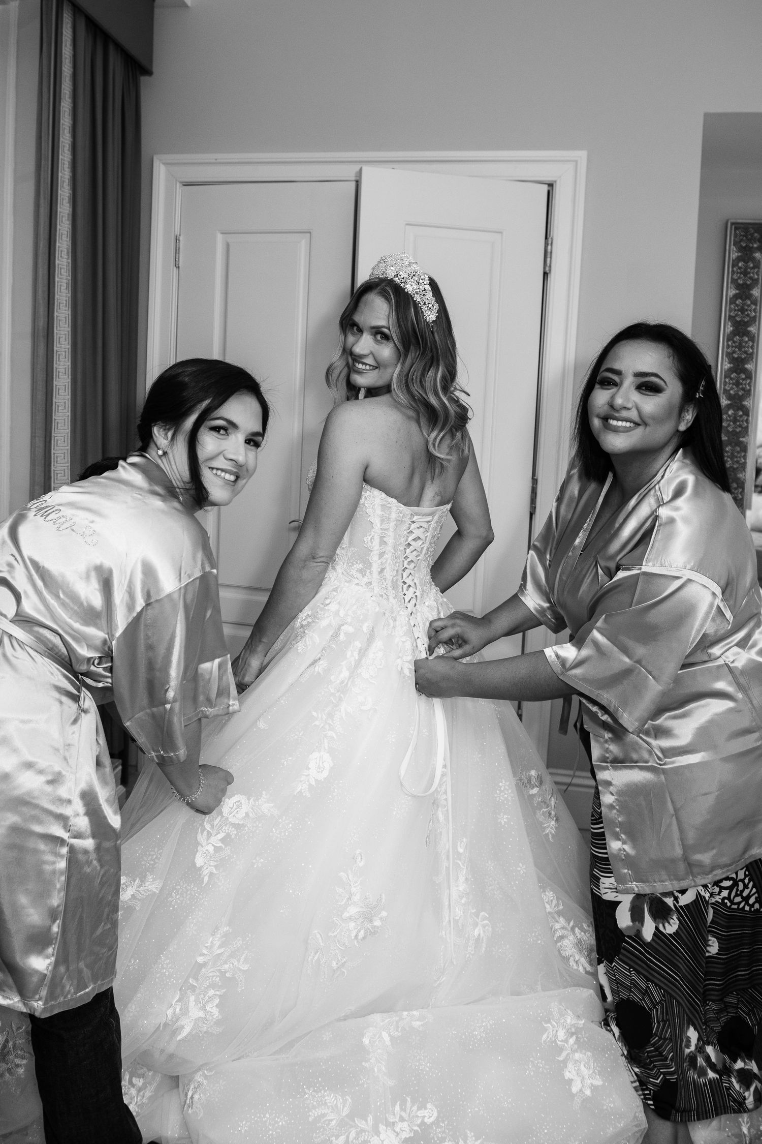 A group wearing matching mint green satin robes poses together for a formal event photo.
