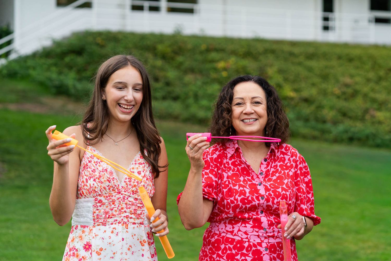 Grandma and granddaughter blowing bubbles together.