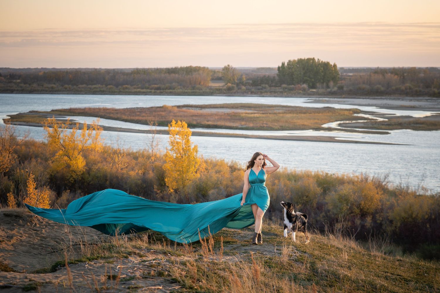 A scenic river valley landscape with golden autumn foliage and winding waterways at sunset.