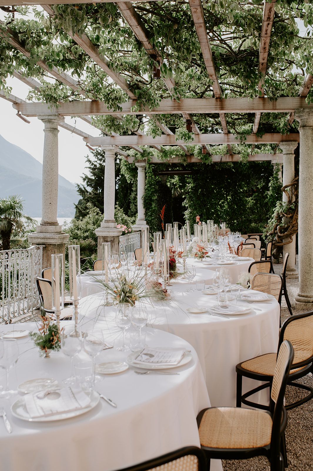 A couple in wedding attire sits intimately on stone steps in a romantic outdoor setting.