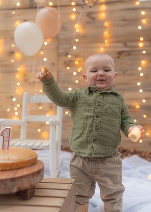 First birthday celebration with balloons and string lights creating festive atmosphere.