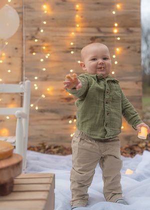 Joyful first birthday celebration with string lights and white balloons as decorations.