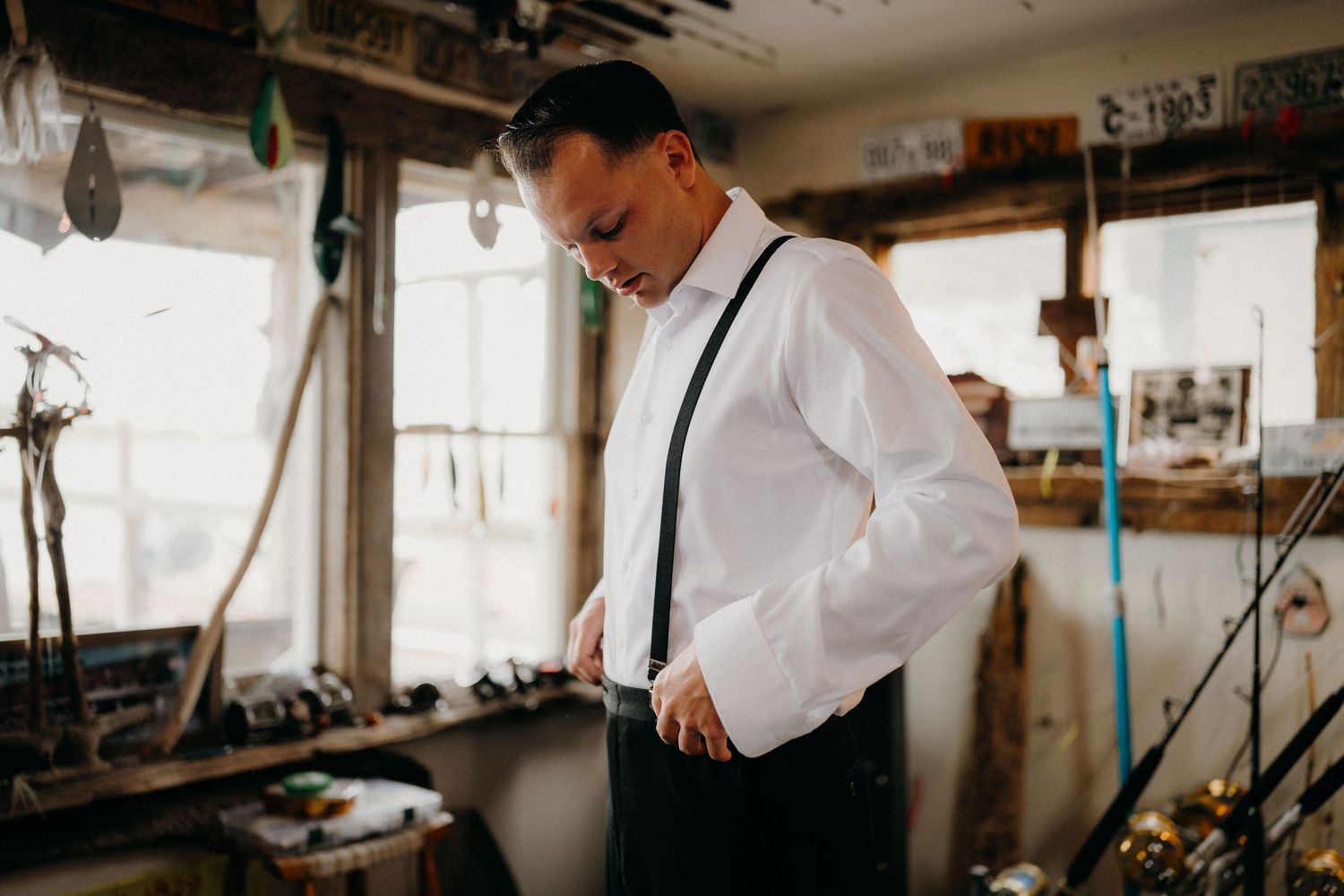 Craftsperson in white shirt working meticulously on jewelry making at a traditional workbench with tools.