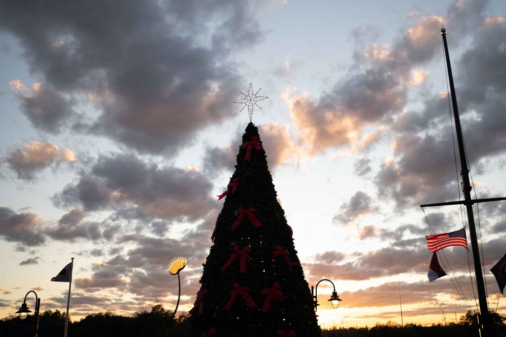 Dramatic sunset sky with silhouetted carnival rides and attractions creating a striking amusement park skyline.