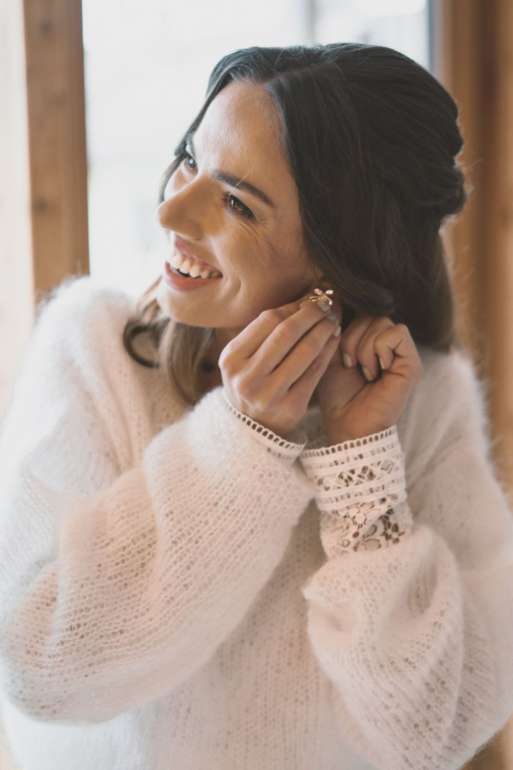 Close-up portrait in a cozy white knit sweater with delicate pearl details and elegant jewelry.