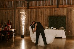 Romantic first dance in a wooden barn with dramatic sparkler lighting effects.