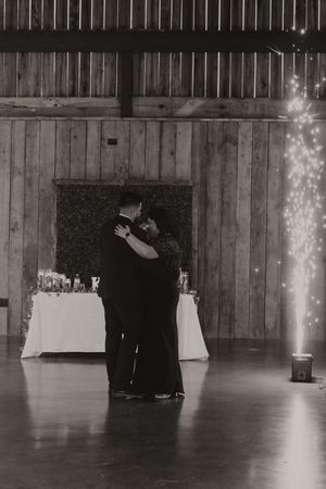 Black and white wedding reception photos in a rustic barn venue with sparkler lighting.