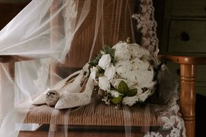 Wedding veil with intricate lace details draped near vintage furniture.