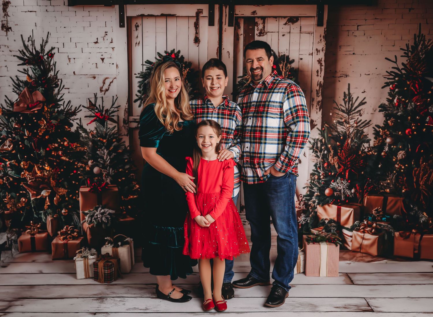 Holiday portrait with decorated Christmas trees and wrapped presents in rustic setting.